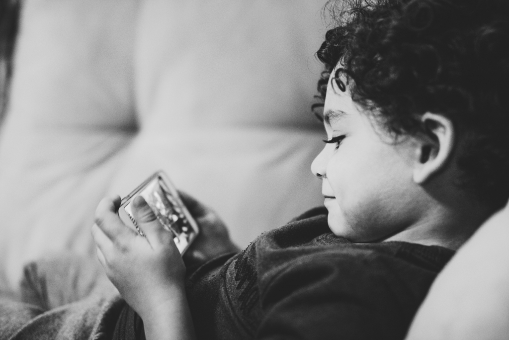 Foto av et barn som spiller på en mobiltelefon